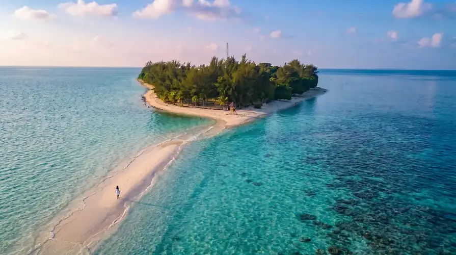 Exploring the white sandy beach of Sibuan Island with Sky Water Villas in the Celebes Sea.